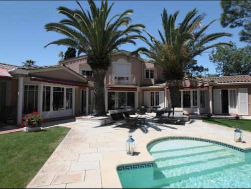 une maison avec une piscine et des palmiers dans l'établissement Villa privée indépendante et Luxueuse au calme, à Narbonne