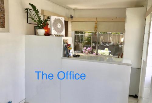 a white kitchen with the office written on it at Cairns Motor Inn in Cairns