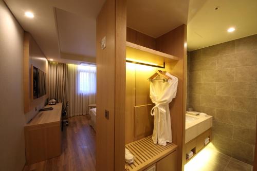 een badkamer met een toilet, een wastafel en een douche bij Benikea The H Hotel in Hwaseong