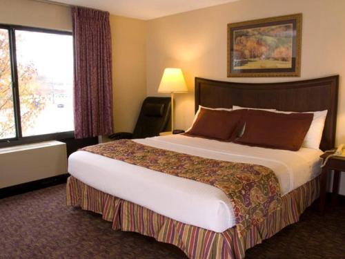 a hotel room with a large bed and a window at Lamplighter Inn-South in Springfield