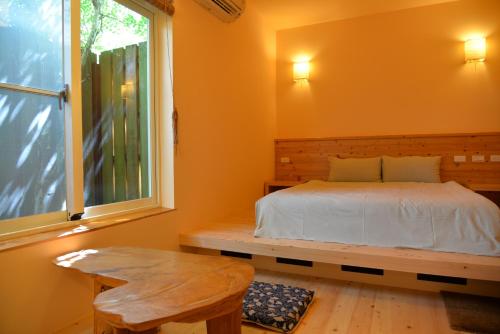 礁溪鄉的住宿－大漁日和，一间卧室设有一张床、一个窗口和一张桌子