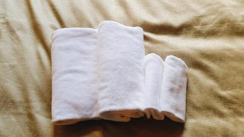 a pair of white towels laying on a bed at Sakura Terrace The Atelier in Kyoto