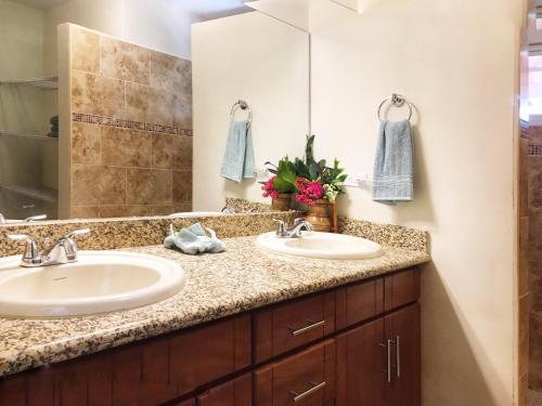 baño con 2 lavabos y espejo grande en Casa Taylor Gran Pacifica Resort en San Diego