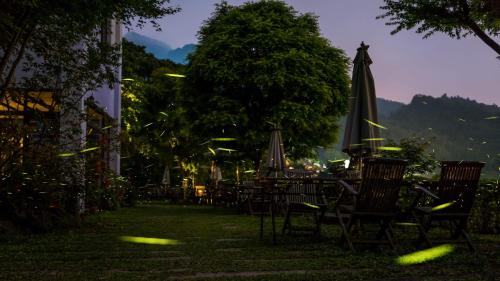 a group of tables and chairs with an umbrella at Maple map B&B in Dahu