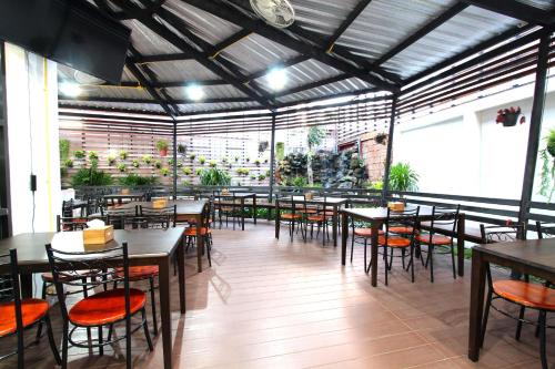 Thanburi Hotel في أودون ثاني: مطعم فيه طاولات وكراسي في الغرفة