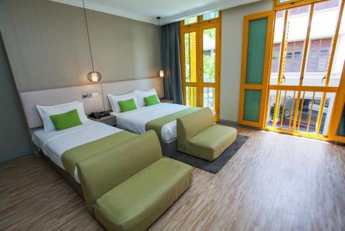 Habitación de hotel con 2 camas y sofá en Champion Hotel, en Singapur