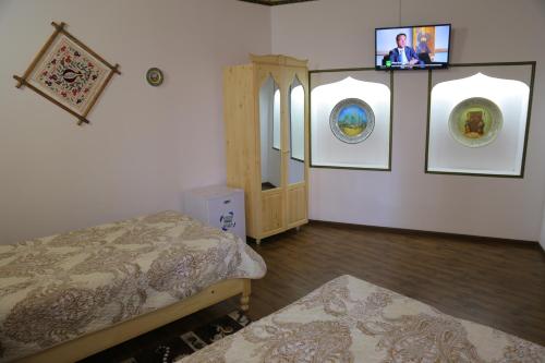 a room with two beds and two pictures on the wall at Rabat Boutique in Samarkand