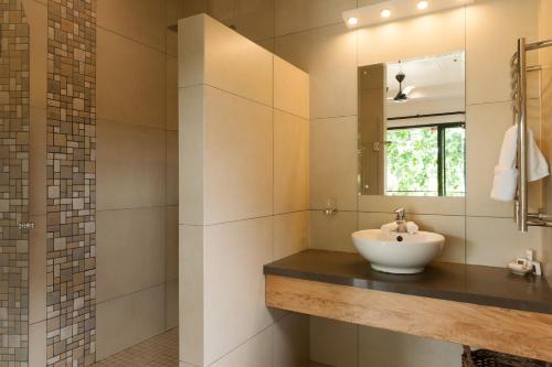 une salle de bain avec un lavabo et un miroir dans l'établissement Le Repaire - Boutique Hotel & Restaurant, à La Digue