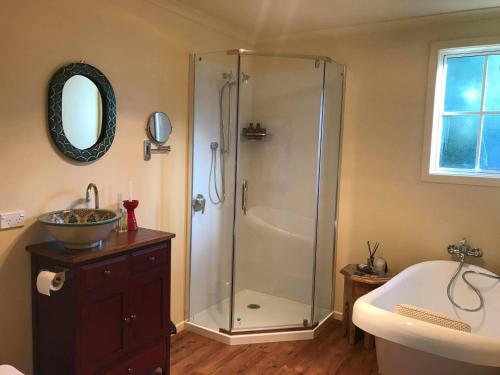 ein Bad mit einer Dusche und einem Waschbecken in der Unterkunft Glascroft Gardens - Bed & Breakfast in Patea