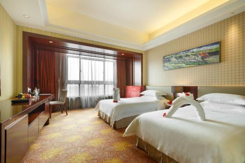 Habitación de hotel con 2 camas y escritorio en Leeden Jingxi Hotel, en Guangzhou