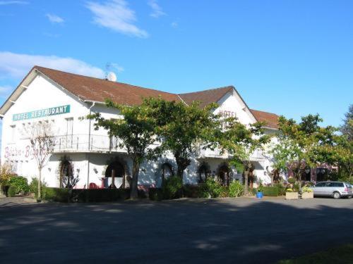 un bâtiment avec une voiture garée devant dans l'établissement Auberge Béarn Bigorre, à Lamarque-Pontacq