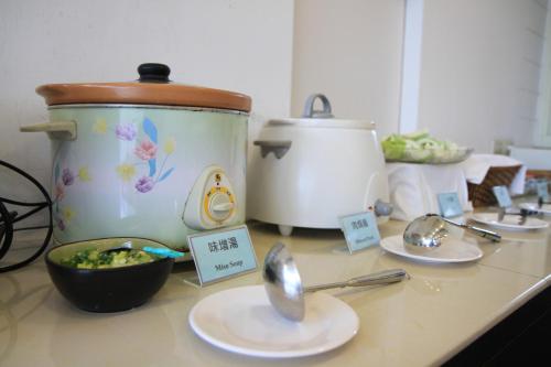 a counter top with a crock pot and plates of food at Ashare Hotel in Jiaoxi