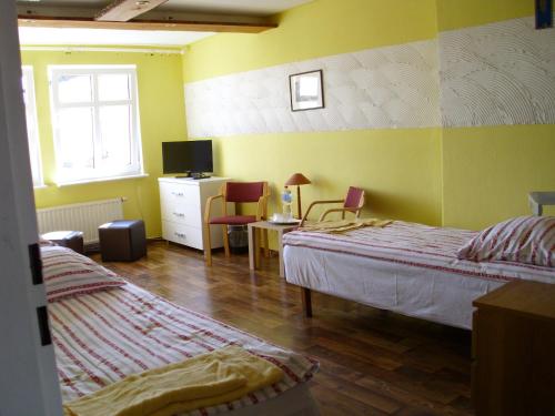 1 dormitorio con 2 camas, escritorio y TV en Pokoje Gościnne Irene en Poznan