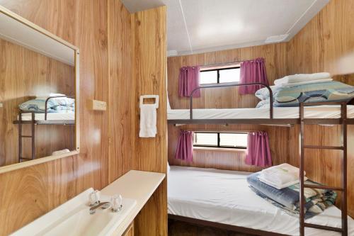 a bathroom with a sink and bunk beds in a room at Benalla Tourist Park in Benalla
