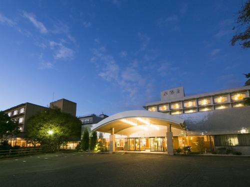 un grand bâtiment avec une façade éclairée la nuit dans l'établissement Hiranoya, à Gamagori