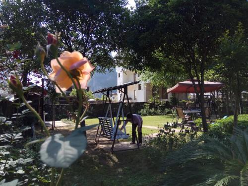 a man working on a playground in a garden at Xingping Our Inn in Yangshuo