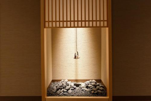 a light in a room with a bowl of rocks at Osaka View Hotel Honmachi in Osaka