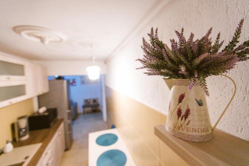a vase with flowers sitting on a shelf in a room at Apartament Maria in Alba Iulia