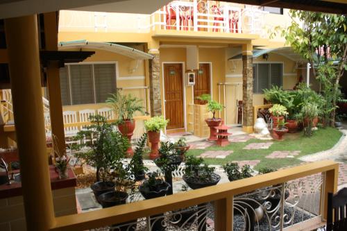 a balcony with a bunch of potted plants at Oslob Malonzo Pension House in Oslob