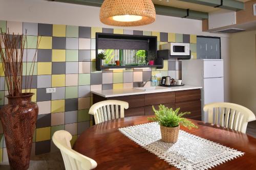 a kitchen with a wooden table and chairs and a kitchen with colorful tiles at Out of Africa Resort in Had Nes