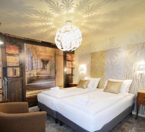 a bedroom with two beds and a chandelier at Hôtel Malar in Paris