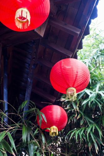 three red paper lanterns hanging from a building at MG Hotel St Michael's Cathedral, Qingdao in Qingdao