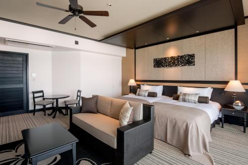 a hotel room with a bed and a couch at Hotel Monterey Okinawa Spa & Resort in Onna
