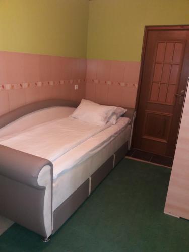 a small bed in a room with a door at Hotel & Restaurant Great Wall - Airport in Sarajevo