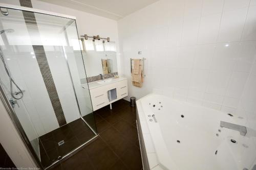baño blanco con ducha y lavamanos en Riverside Ocean Grove, en Ocean Grove