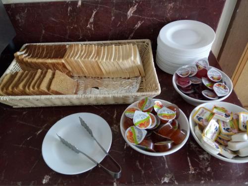 a table topped with plates and bowls of food at Hotel Airlink Castle in Nedumbassery