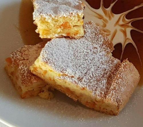 two pieces of cake with powdered sugar on a plate at Iris Hotel in Oradea