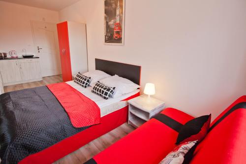 Un dormitorio con una cama roja y negra y un sofá en Błękit Oceanu en Władysławowo