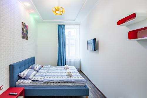 リヴィウにあるMedova8の青いベッドと窓付きの小さなベッドルームが備わります。