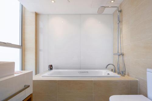 uma banheira na casa de banho com WC em Summit View Kowloon em Hong Kong