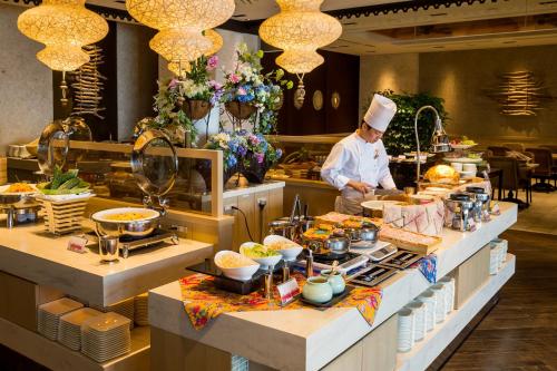 a chef preparing food in a restaurant kitchen at Hotel Monterey Okinawa Spa & Resort in Onna