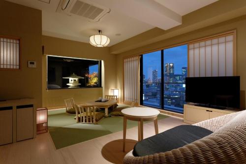 a living room with a large window with a view of a city at Osaka View Hotel Honmachi in Osaka
