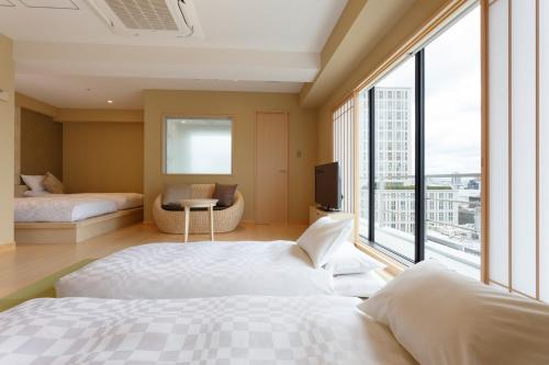 a bedroom with two beds and a large window at Osaka View Hotel Honmachi in Osaka