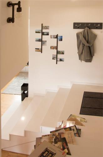 a room with a white staircase with photos on the wall at Vintage Design Apartment in Gornja Radgona