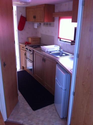 a small kitchen with a sink and a stove at Sealands Ingoldmells 6 Berth Panel heated Baysdale in Ingoldmells