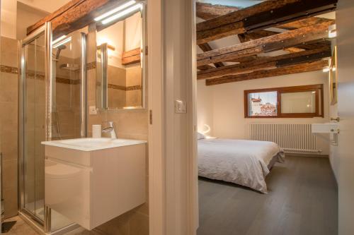 a bathroom with a sink and a bed in a room at SAINT MARK'S BASILICA @200 meters in Venice
