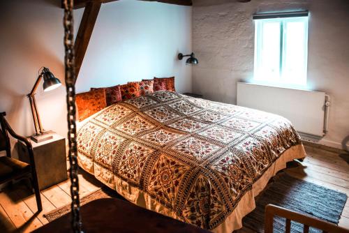 a bedroom with a bed in a room with a window at Andelen Guesthouse in Ærøskøbing