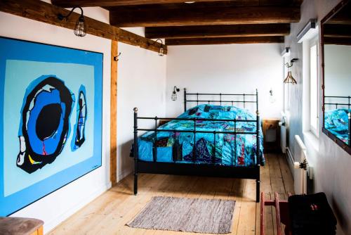 a bedroom with a bed with a blue comforter at Andelen Guesthouse in Ærøskøbing