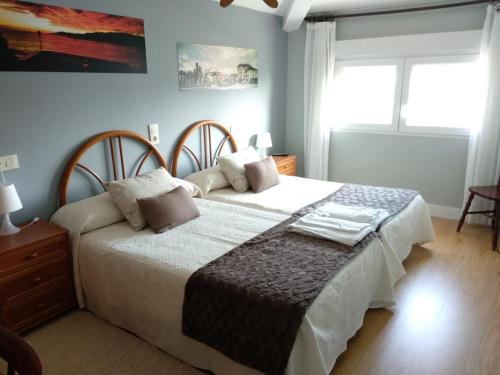 1 dormitorio con 2 camas y ventana en Hostal Buenavista, en San Ciprián
