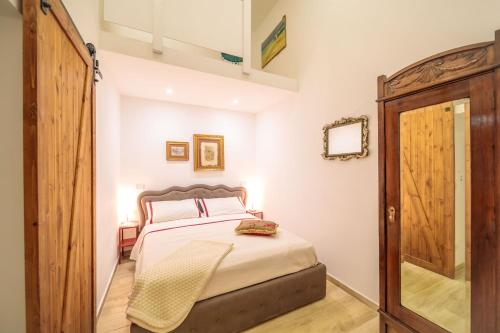 a bedroom with a bed and a wooden door at "Il principio di Archimede"guest & art house in Siracusa