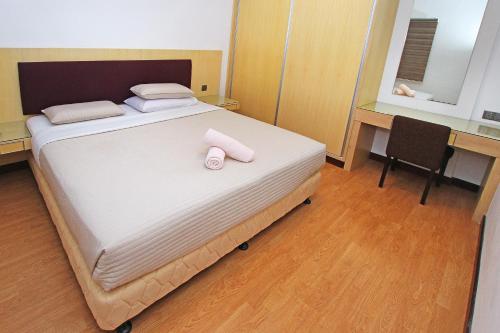 a bedroom with a bed with two towels on it at Bernard Holiday Home @ Imperial Suites Kuching in Kuching
