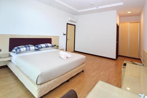 a bedroom with a large white bed with blue pillows at Bernard Holiday Home @ Imperial Suites Kuching in Kuching