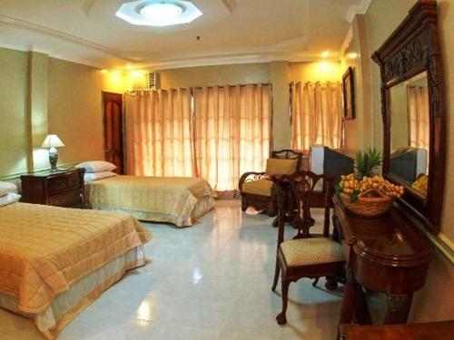Camiguin Highland Resort في مامباجاو: غرفة فندقية بسريرين ومكتب