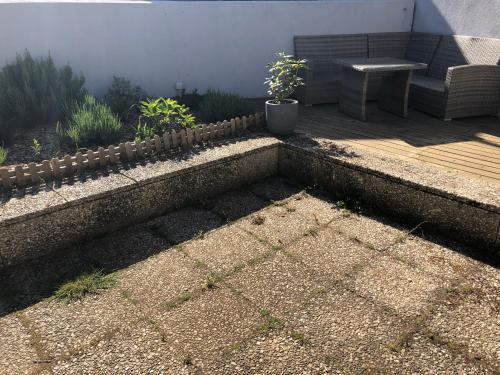 a patio with a bench and a wooden deck at La Demeure d'Alexandra in Cholet