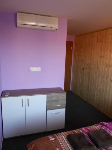 a bedroom with a white cabinet and a bed at Penzion Imrichovi in Moravská Nová Ves