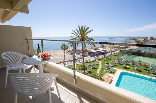 balcón con mesa, sillas y vistas al océano en La Barracuda, en Torremolinos